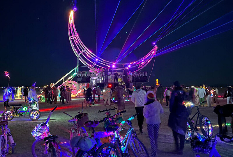 Burning Man at night with a laser light show